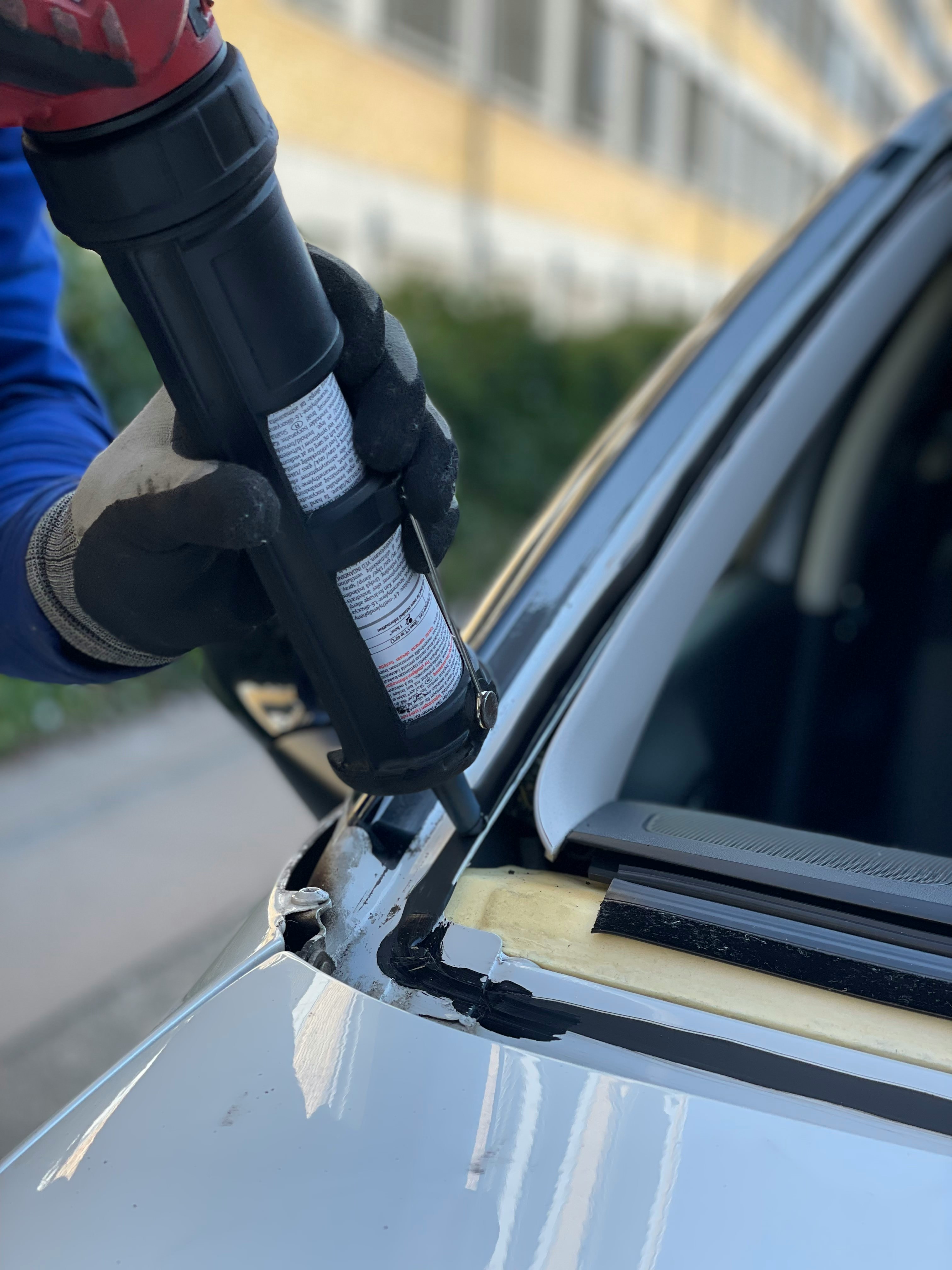 Auto glass technician applying urethane sealant during a windshield installation in the Tri-Cities, WA